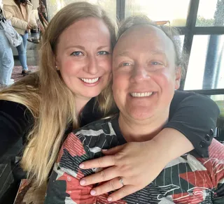 A close-up selfie of Dr.Andrea and her husband smiling, indicating a family portrait.